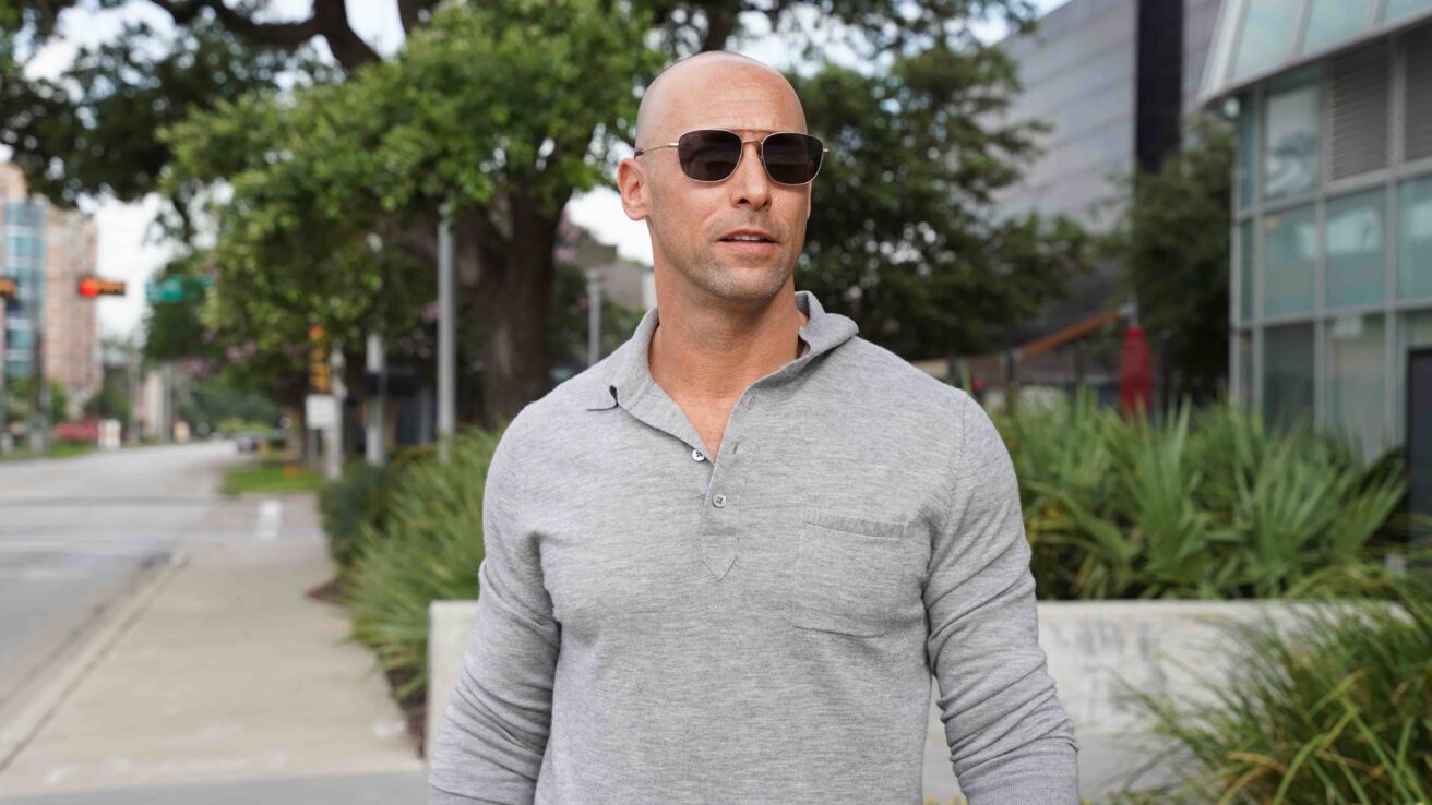 man in grey shirt walking down street