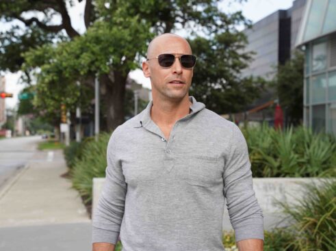 man in grey shirt walking down street