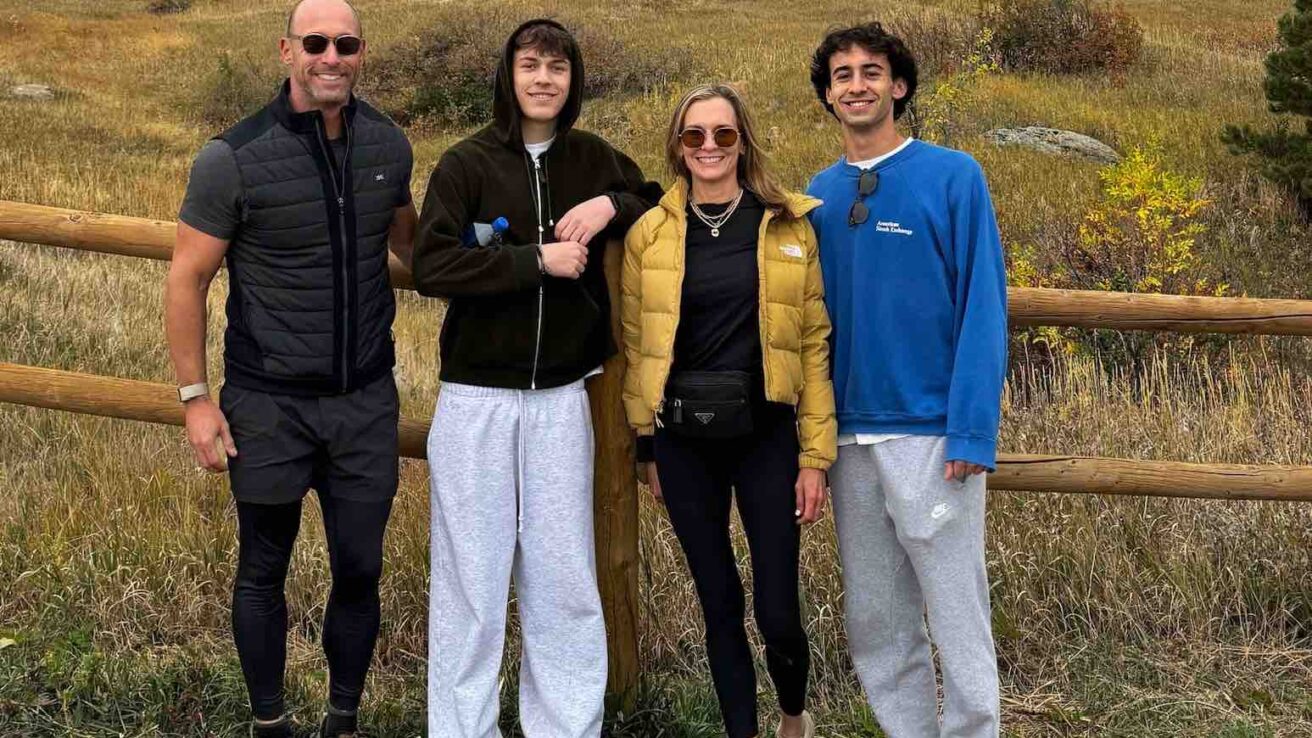 greg scheinman and family standing and smiling in front of a fence